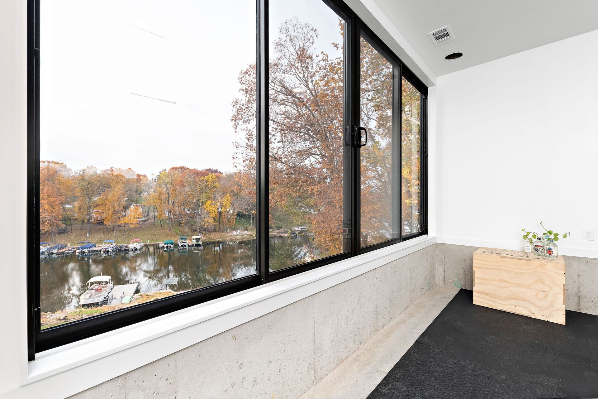 A large window in a room with a view of a lake.