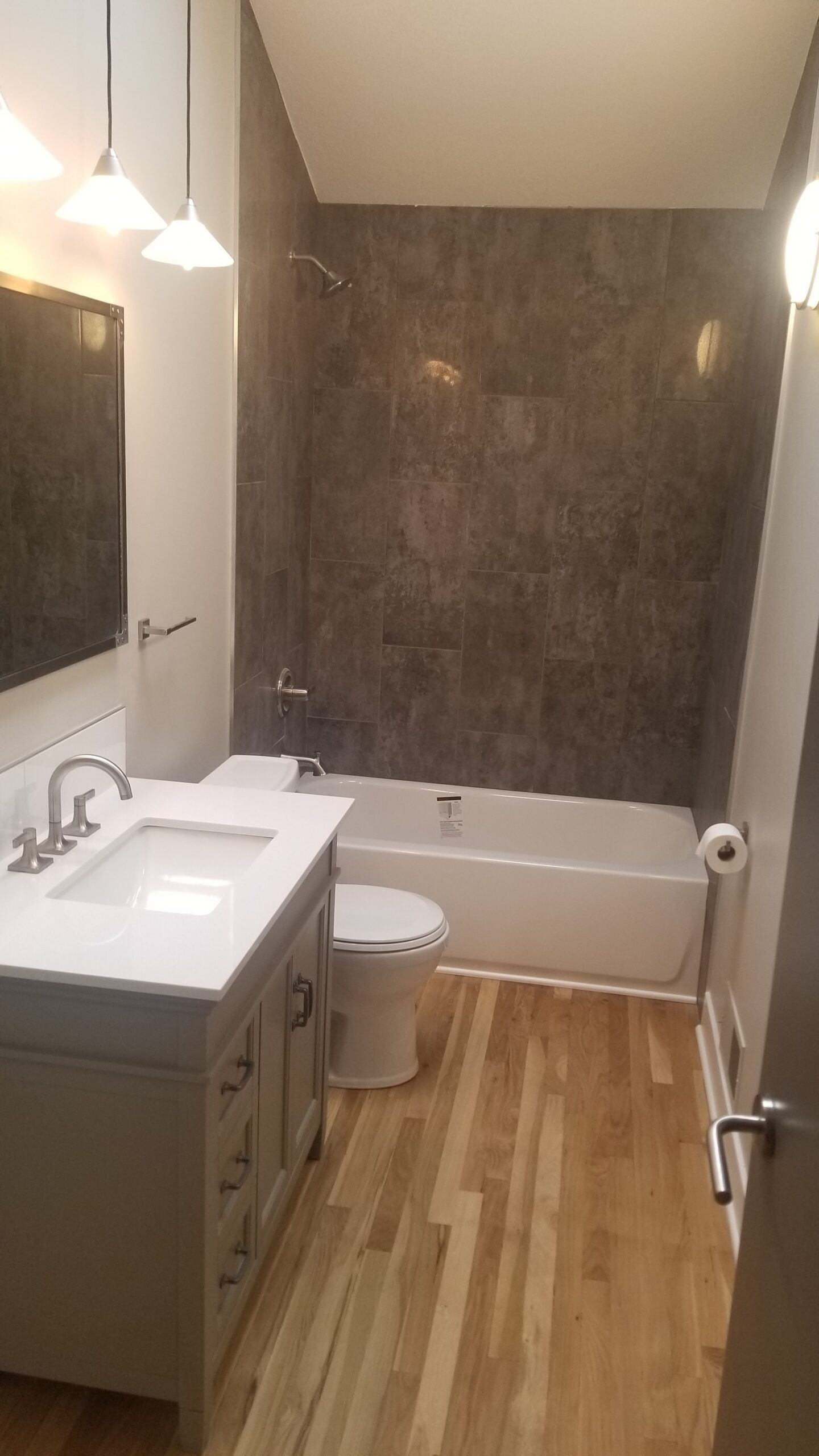 A bathroom with a sink , toilet , bathtub and mirror.