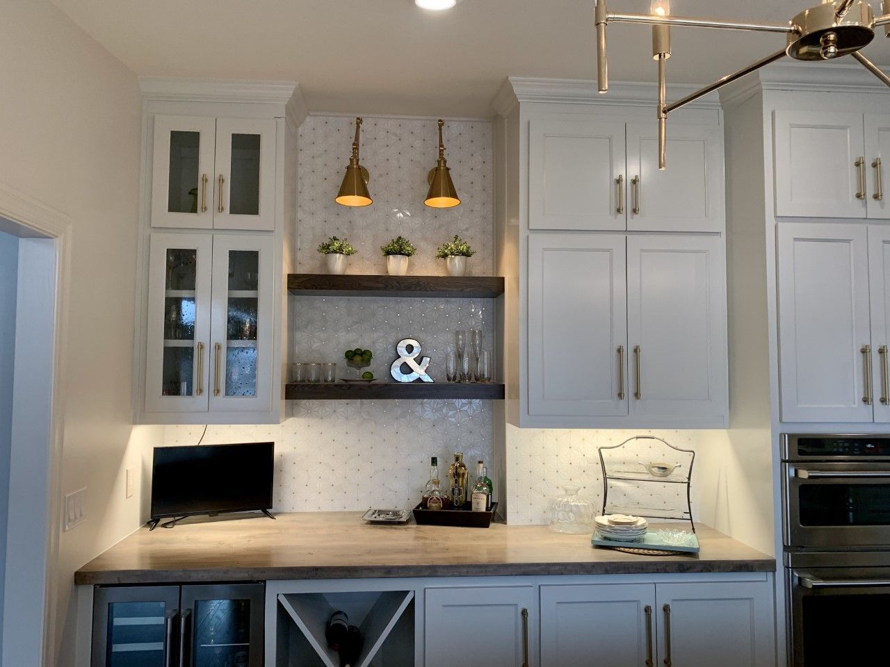 A kitchen with white cabinets and a wine rack