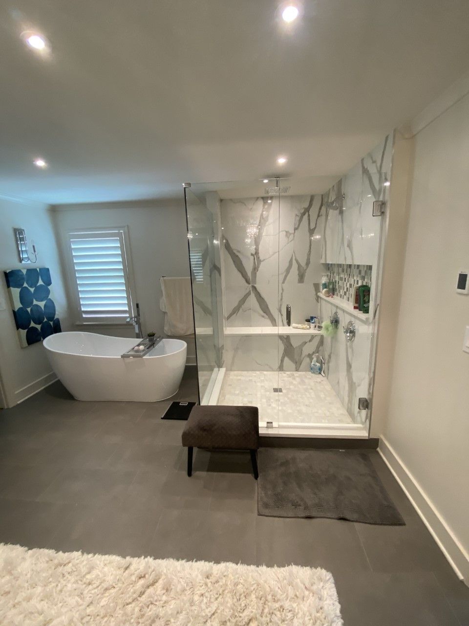 A bathroom with a tub , shower , and rug.