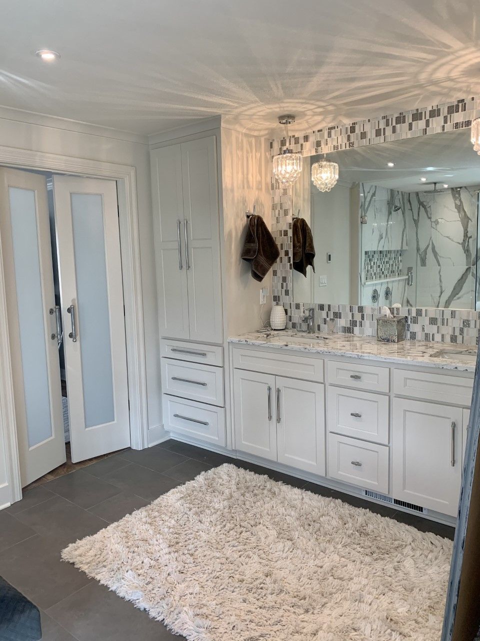 A bathroom with two sinks , a large mirror and a rug.