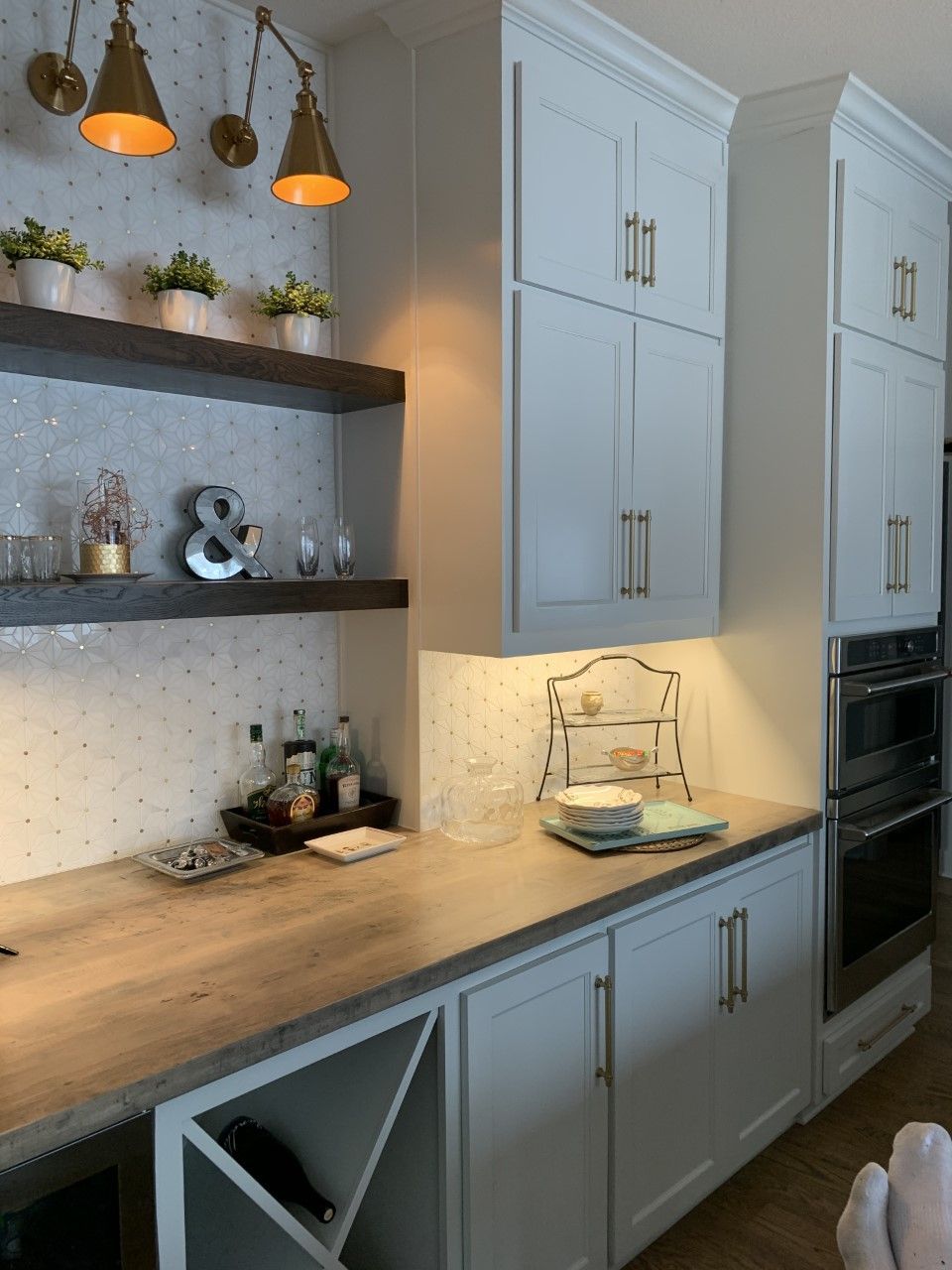 A kitchen with white cabinets and a wine rack