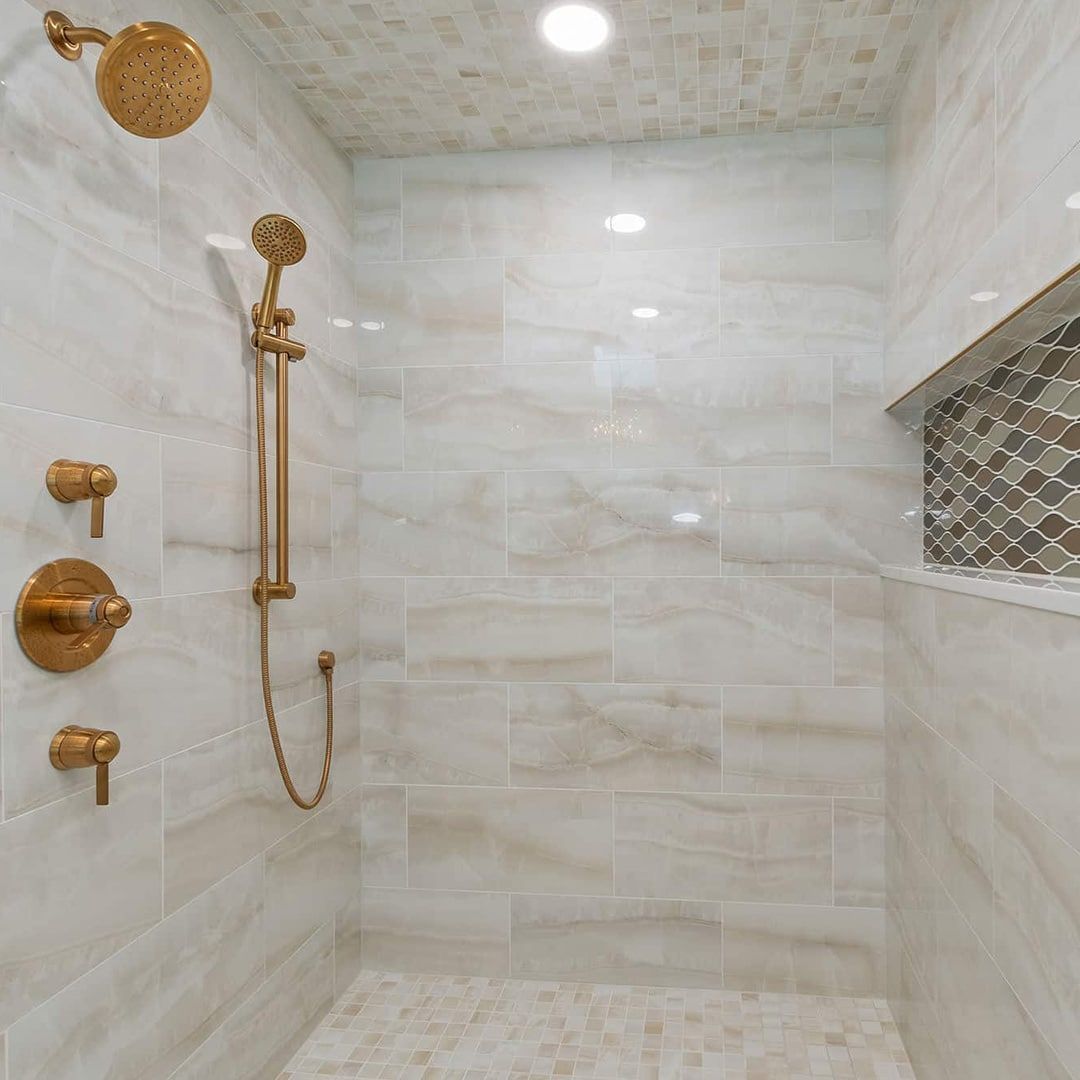 A shower with a brass shower head and faucets