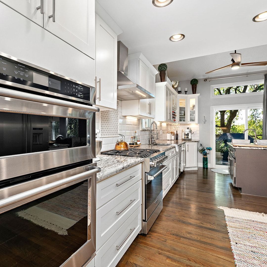 A kitchen with stainless steel appliances and white cabinets