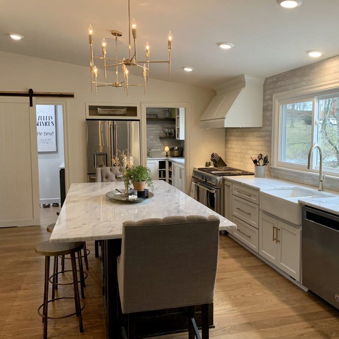 A kitchen with a long table and chairs in it.