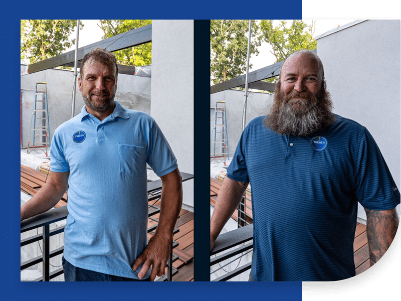 Two men with beards are standing next to each other on a balcony.