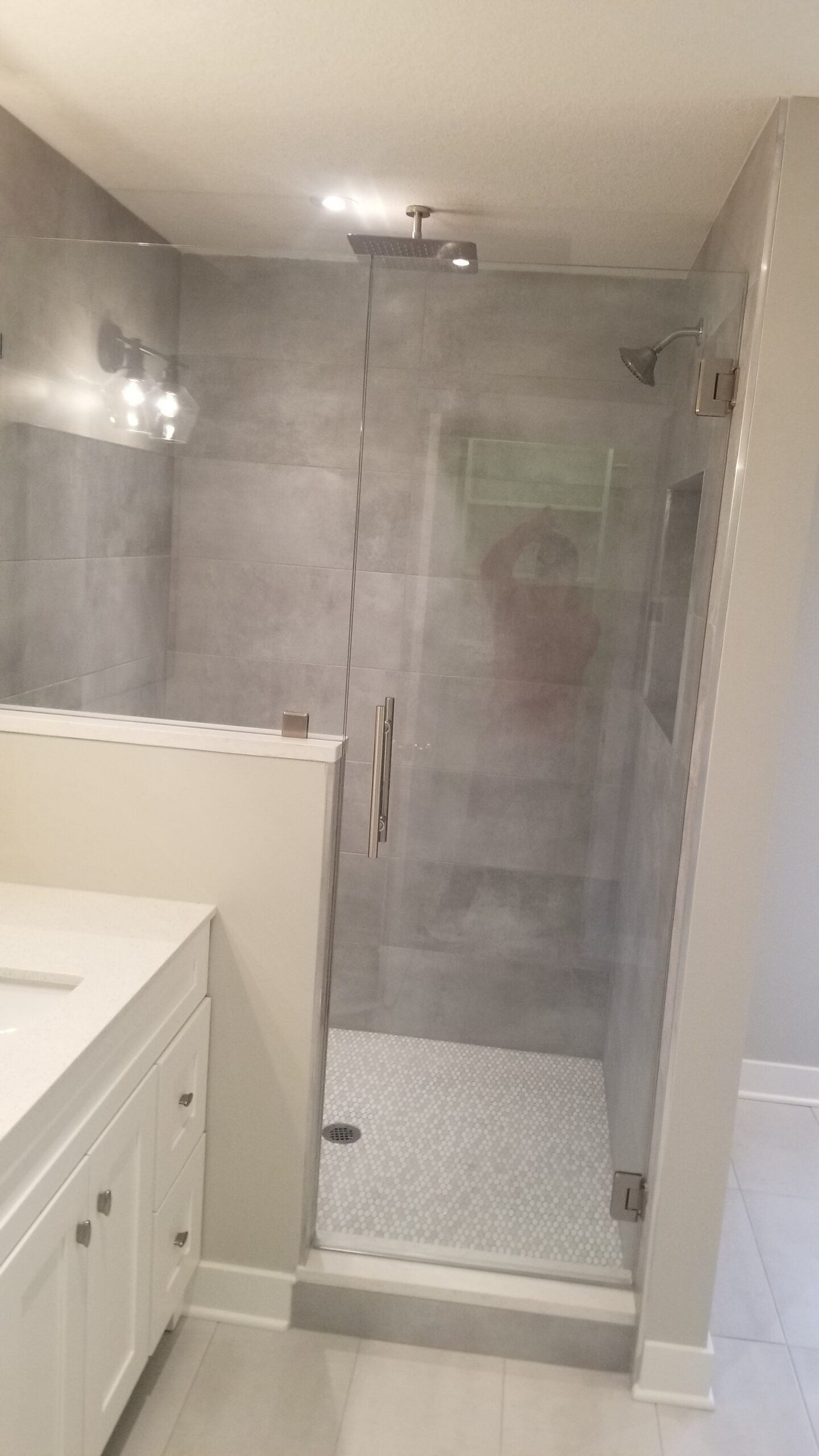 A bathroom with a walk in shower and a sink.
