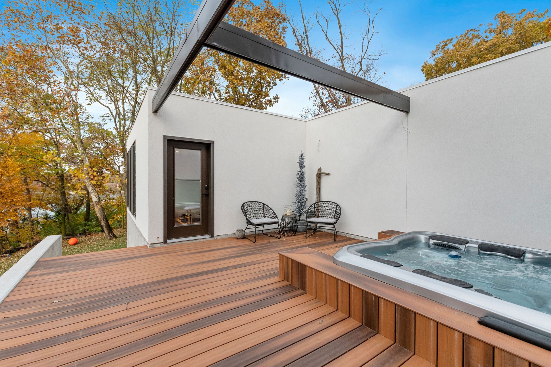 There is a hot tub on the deck of a house.