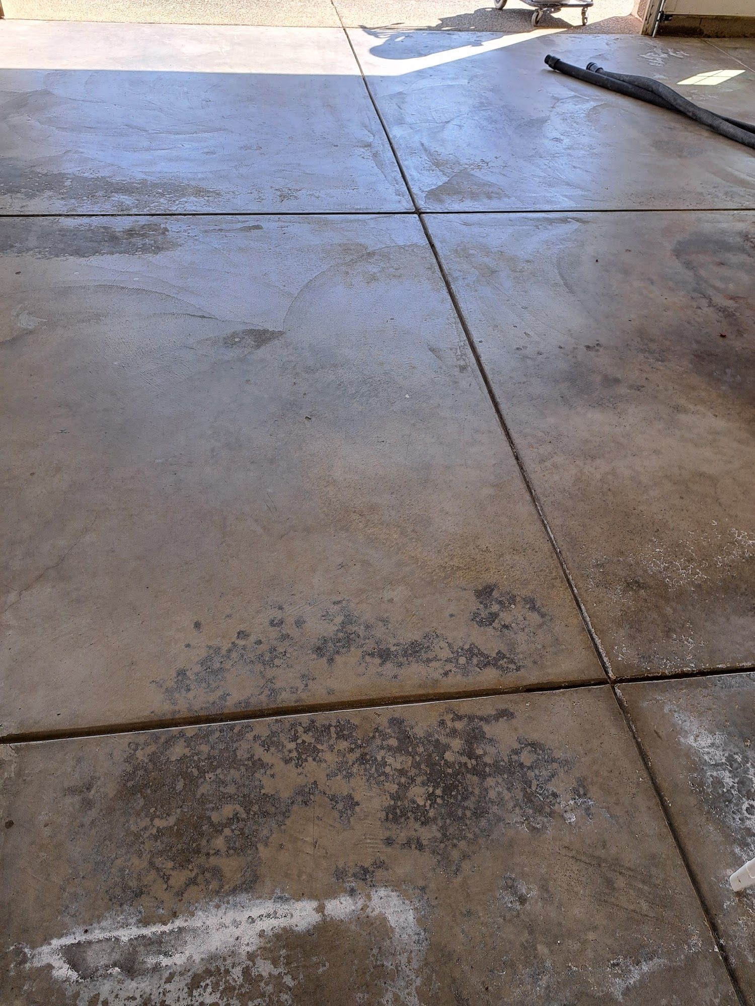 Concrete garage floor with stained areas and control joints.