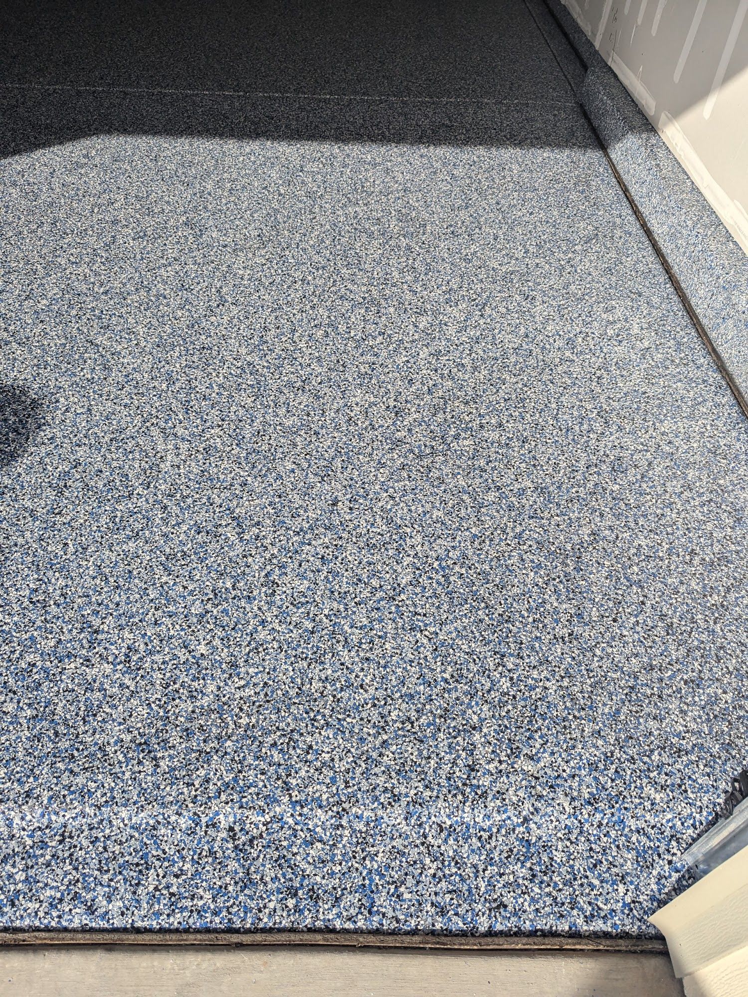 Blue and white speckled epoxy floor in a garage.