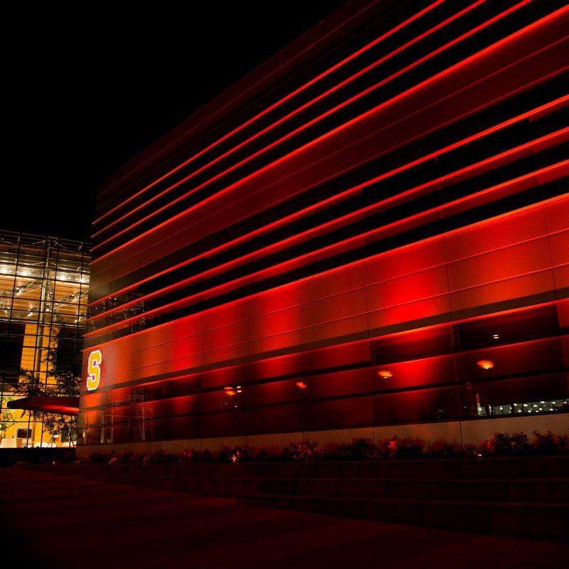 Red-lit stadium at night with horizontal light bands, a large 