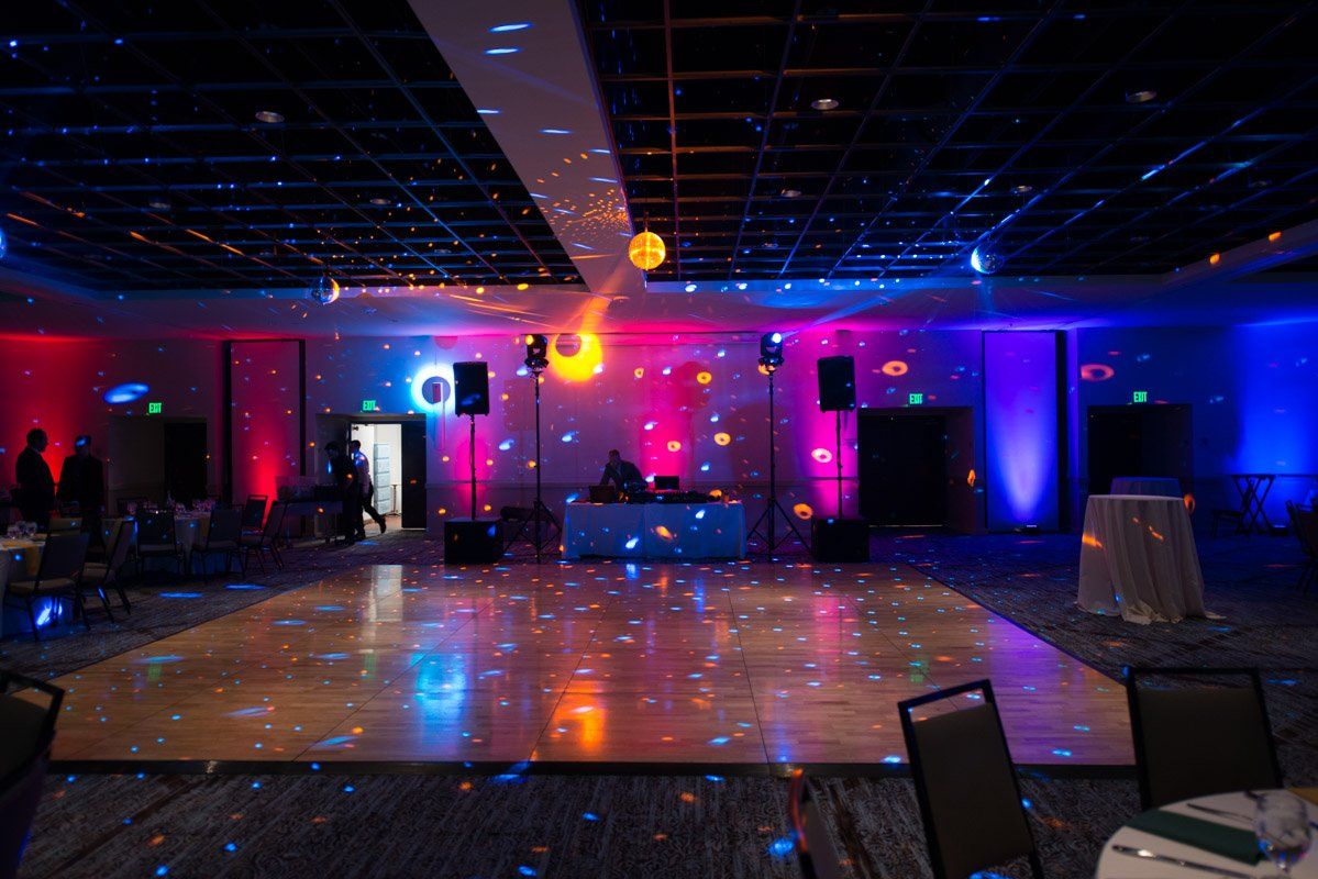 A dance floor lit with blue and red lights for a party or event in a large room.