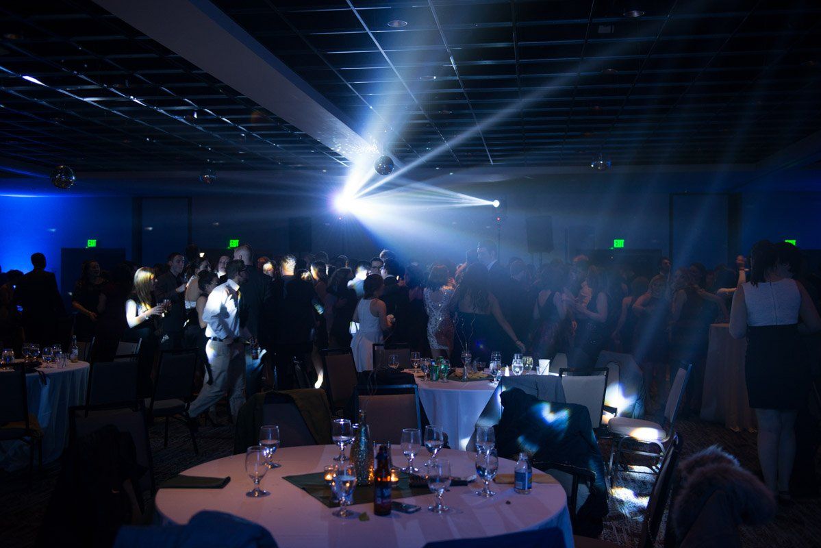 People dancing at a party in a dark room lit with bright blue spotlights.