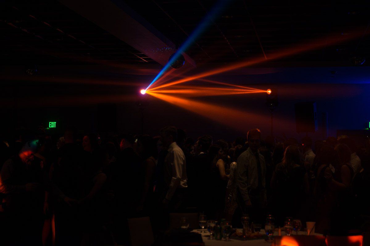Orange and blue spotlights over a crowded dance floor, creating a colorful, vibrant atmosphere.