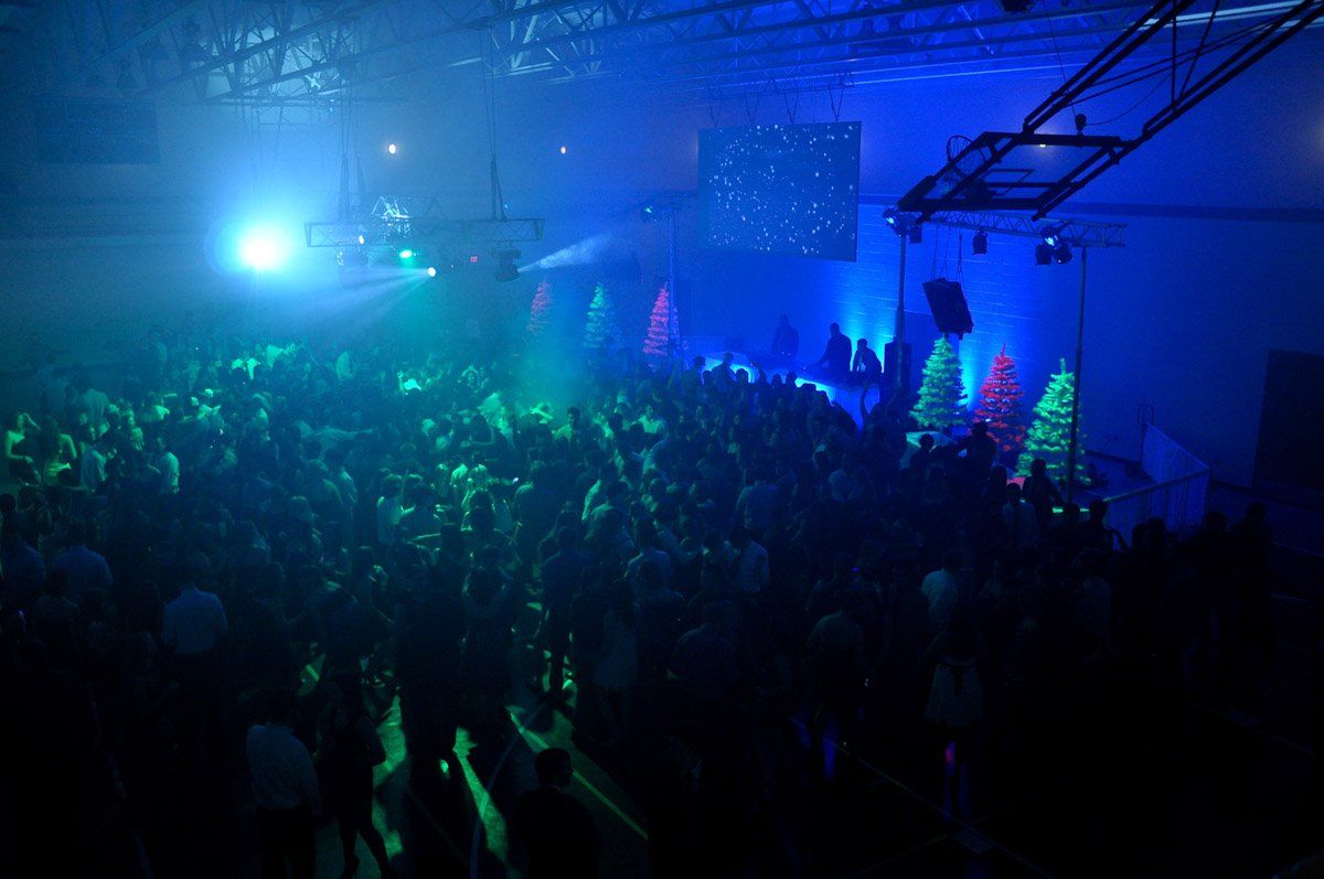 Crowd at a concert bathed in blue and green stage lighting.