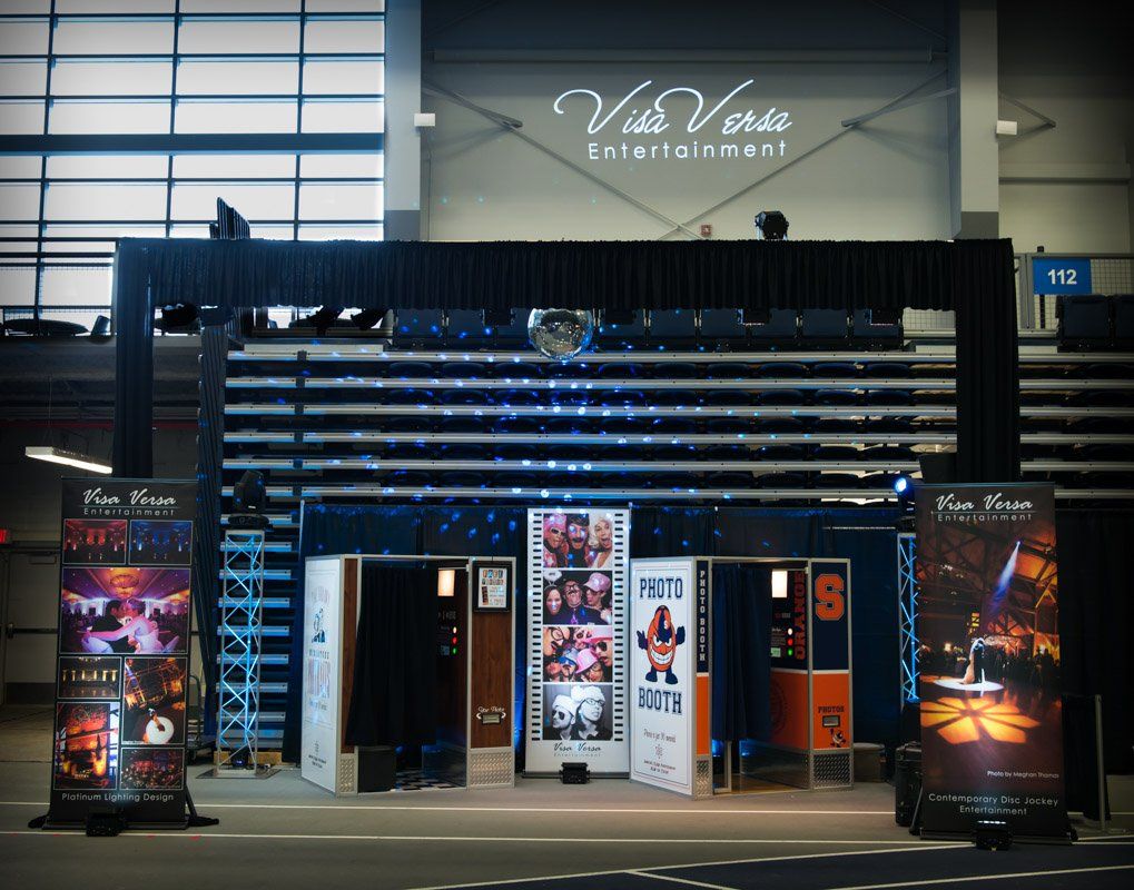 Photo booth setup at an event. Includes booths, backdrops, and promotional banners, under the 