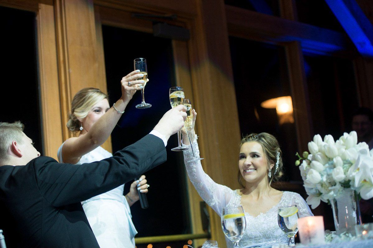 Wedding toast with bride, groom, and bridesmaid, holding champagne glasses.