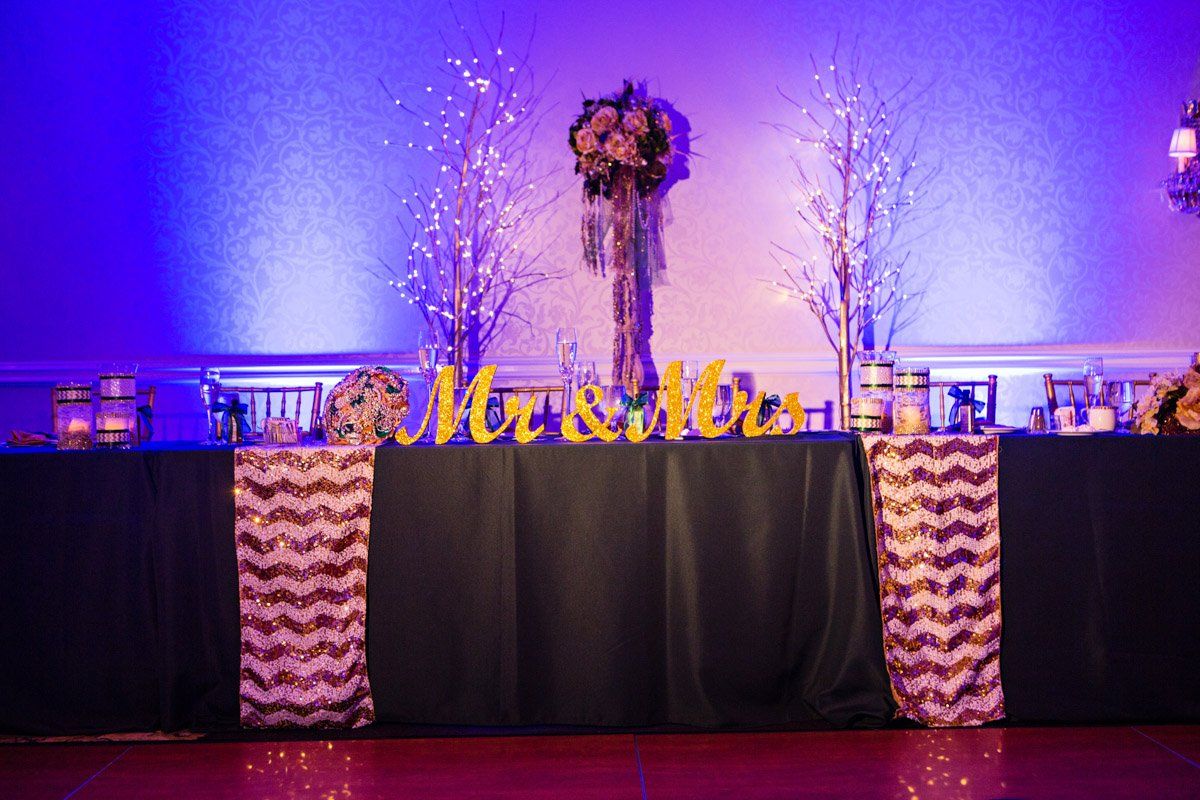 Wedding reception head table with floral arrangement and 