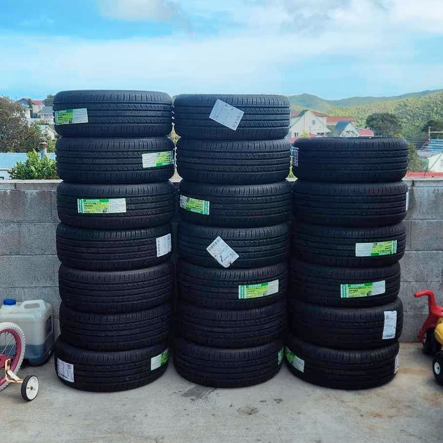 A stack of tires with green stickers on them