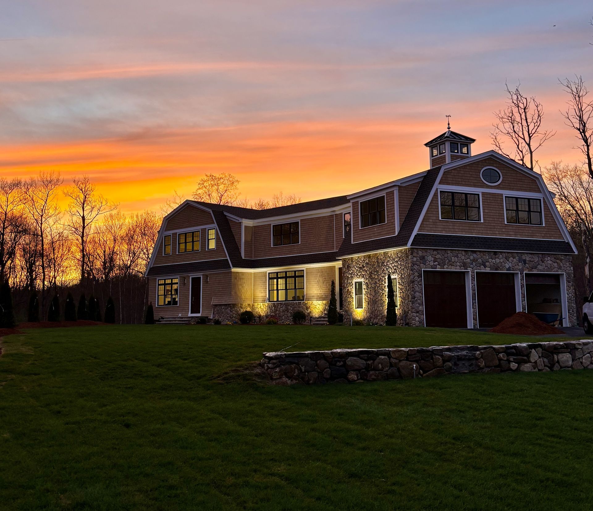 A large house with a sunset in the background