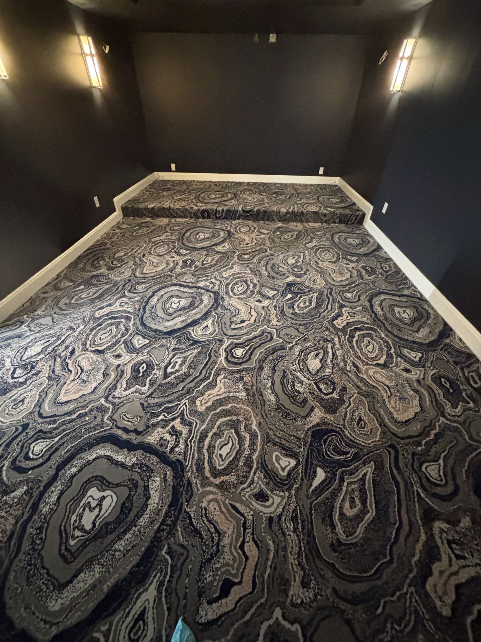 A large room with a carpeted floor and stairs.