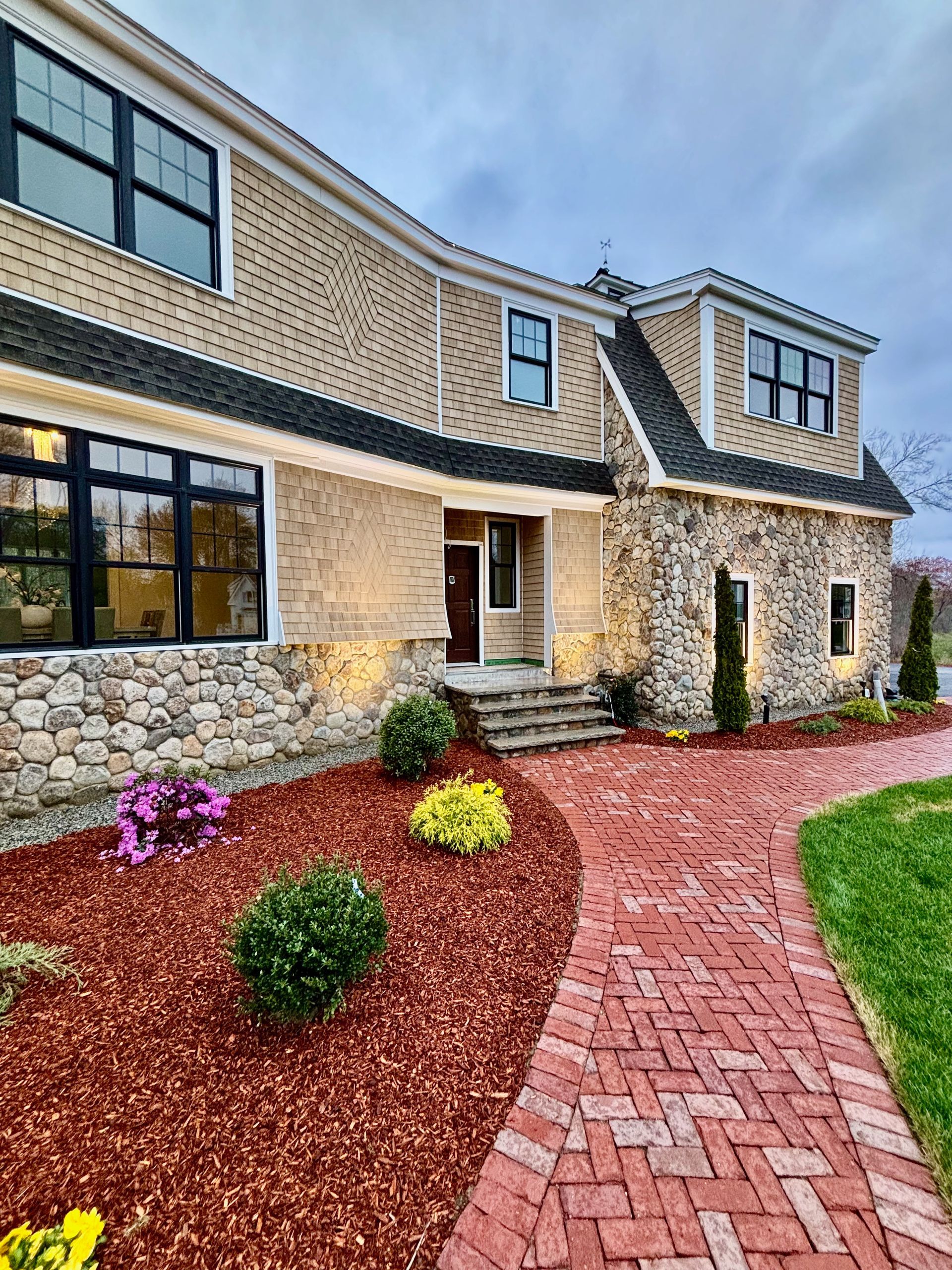 A large house with a brick walkway leading to it.
