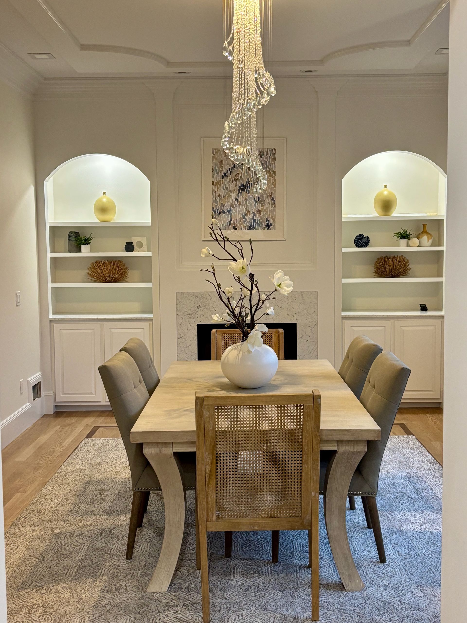 A dining room with a table and chairs and a chandelier
