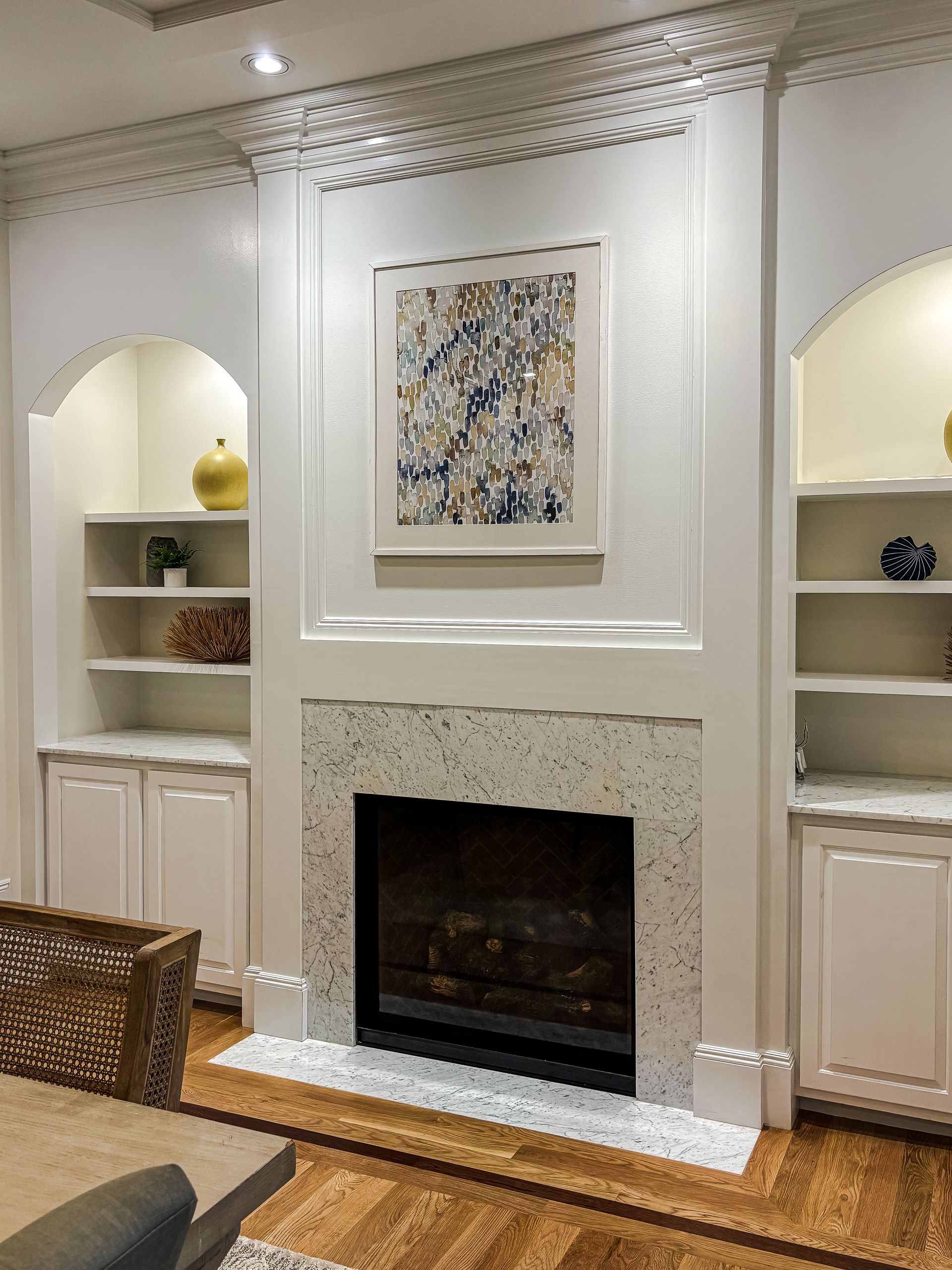A living room with a fireplace and a picture on the wall.