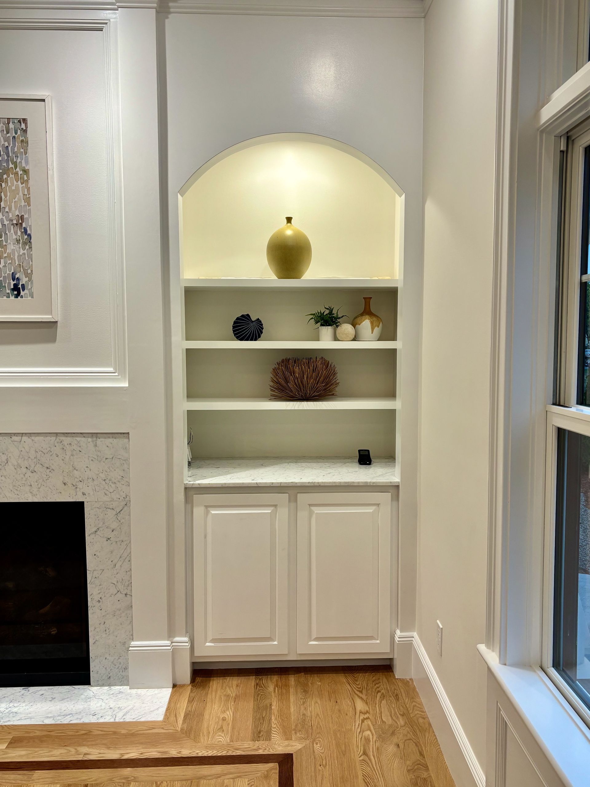 A living room with a fireplace and built in shelves