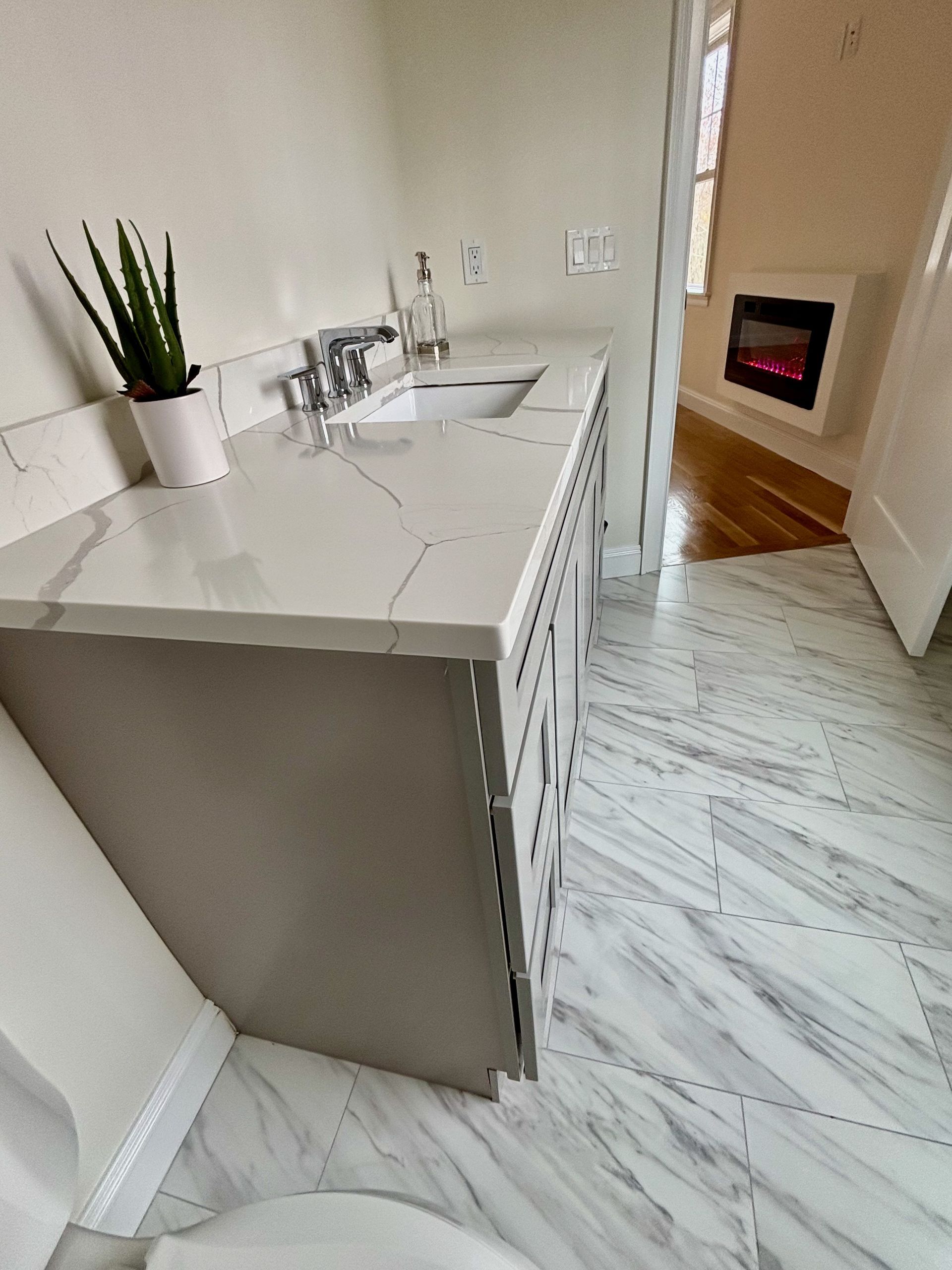 A bathroom with a sink , toilet and fireplace.