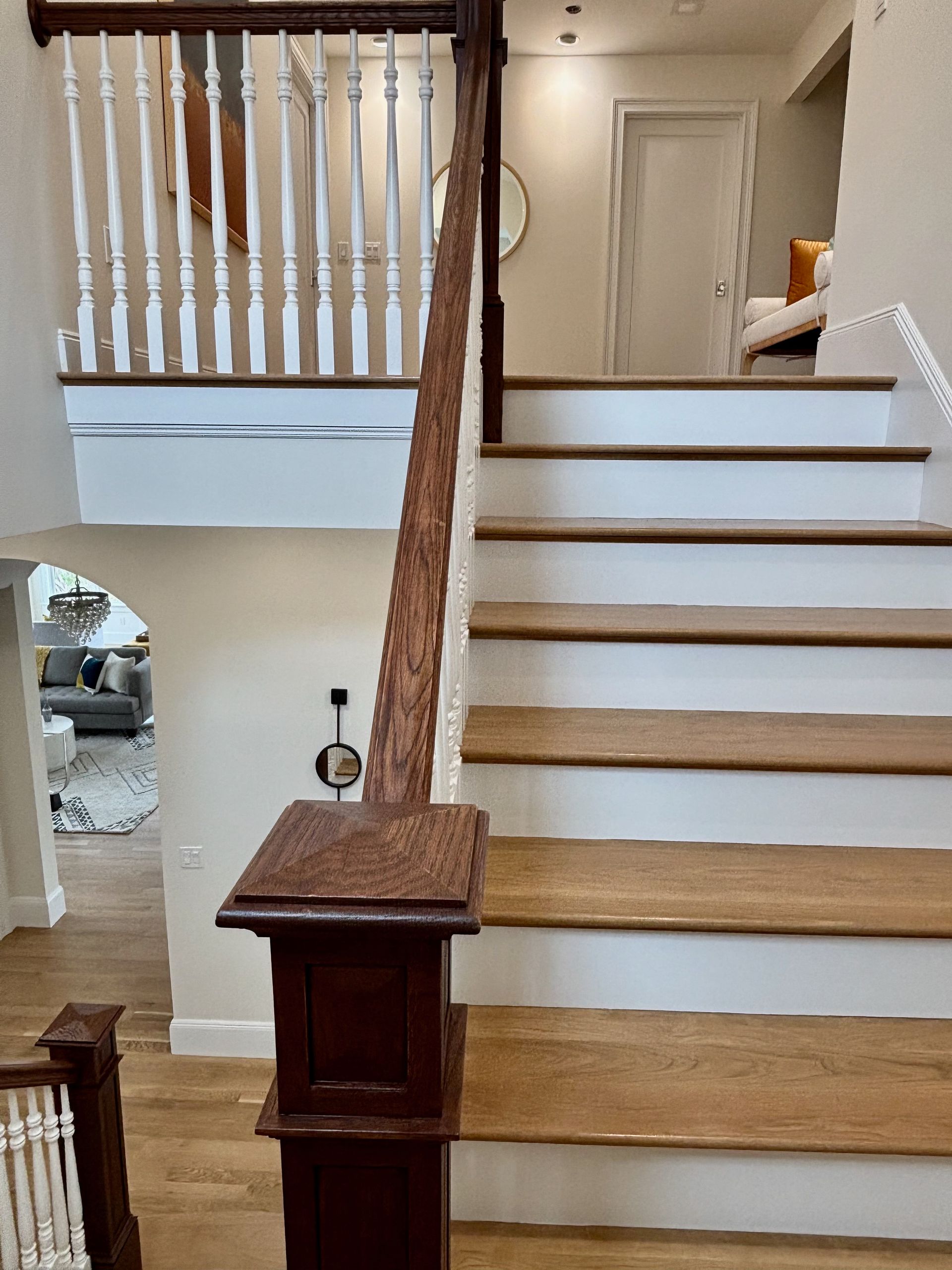 A wooden staircase with white steps and a wooden railing in a house.
