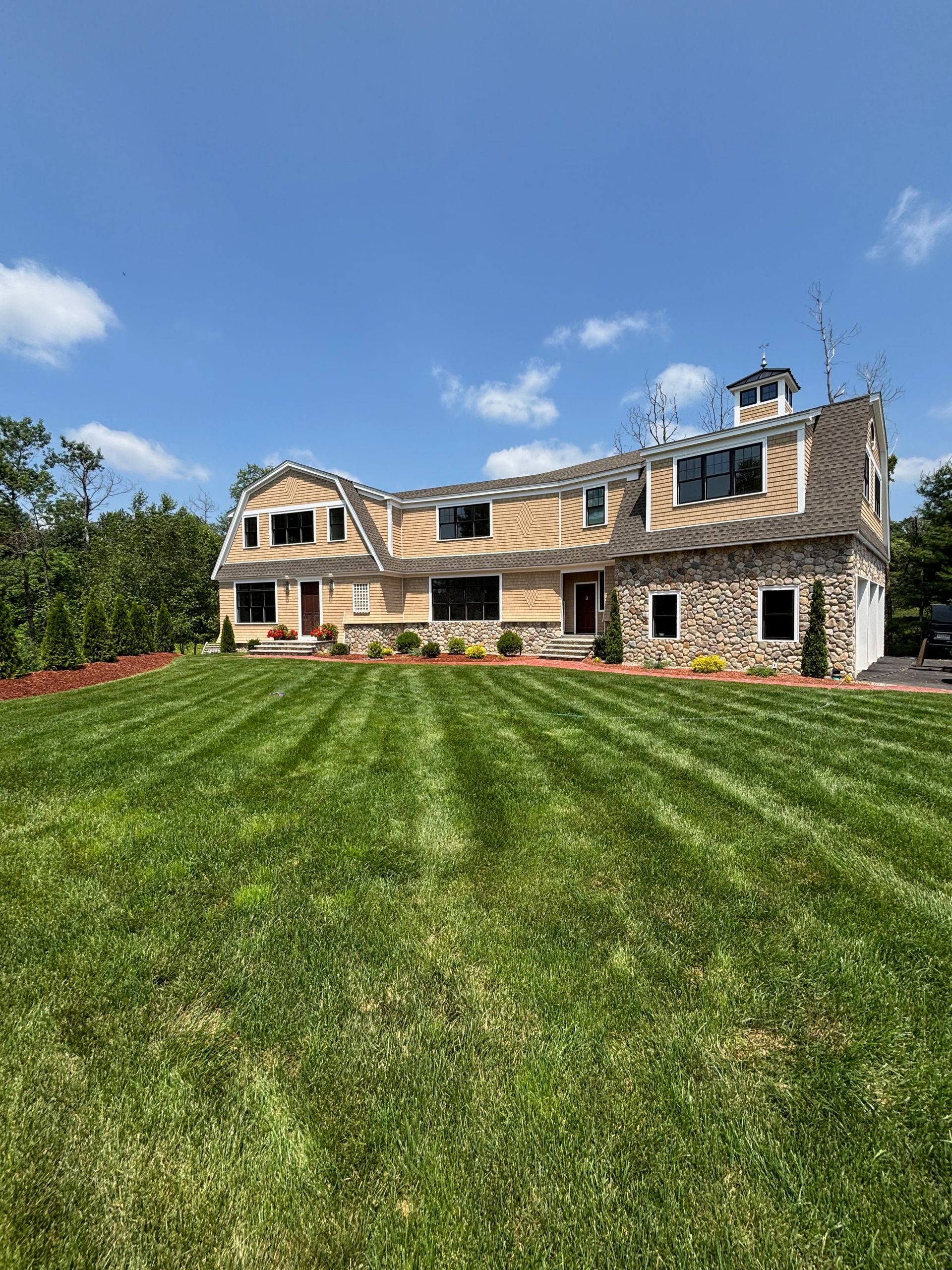 A large house with a lush green lawn in front of it.