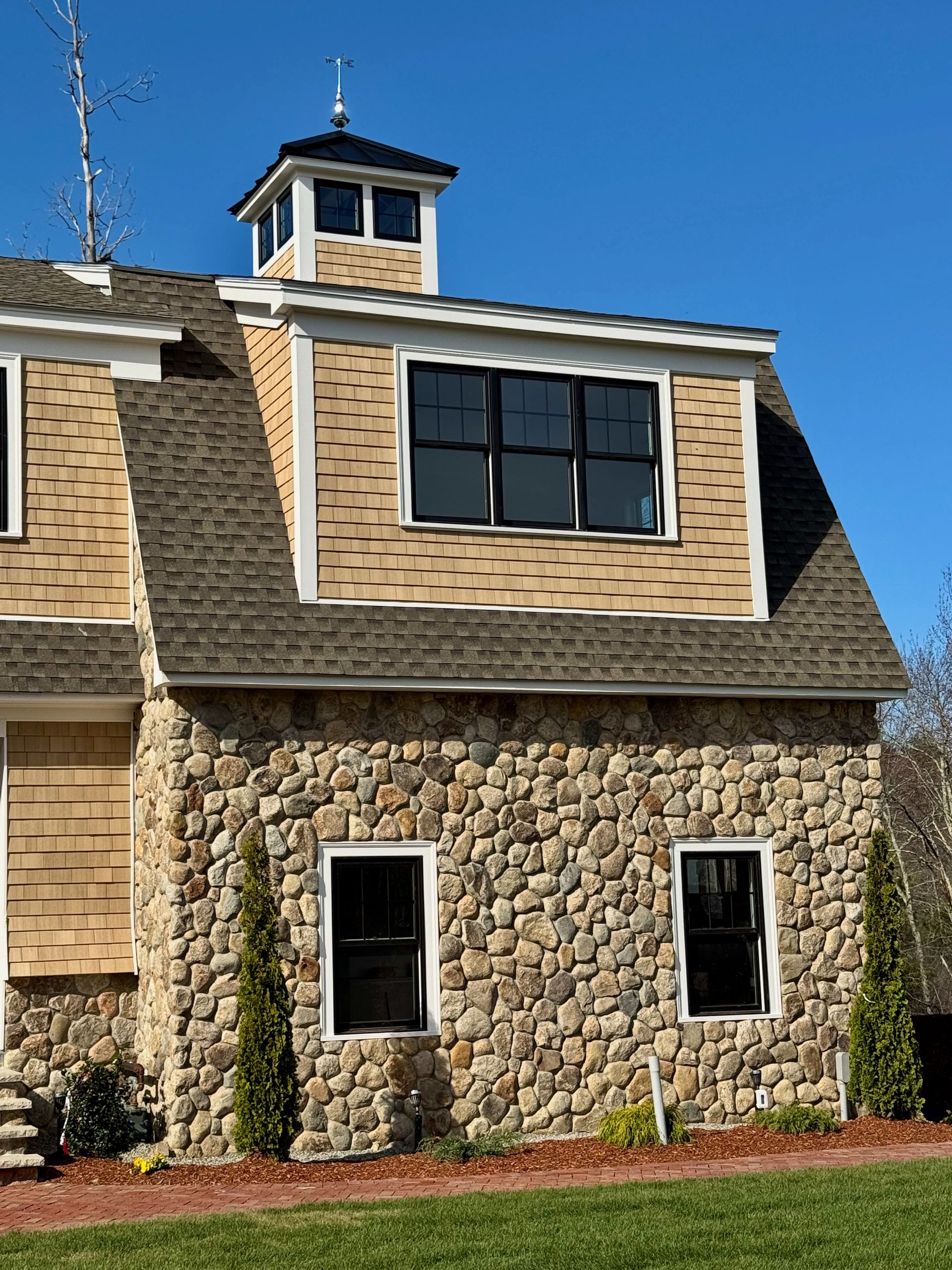 A house with a stone wall and a wooden roof