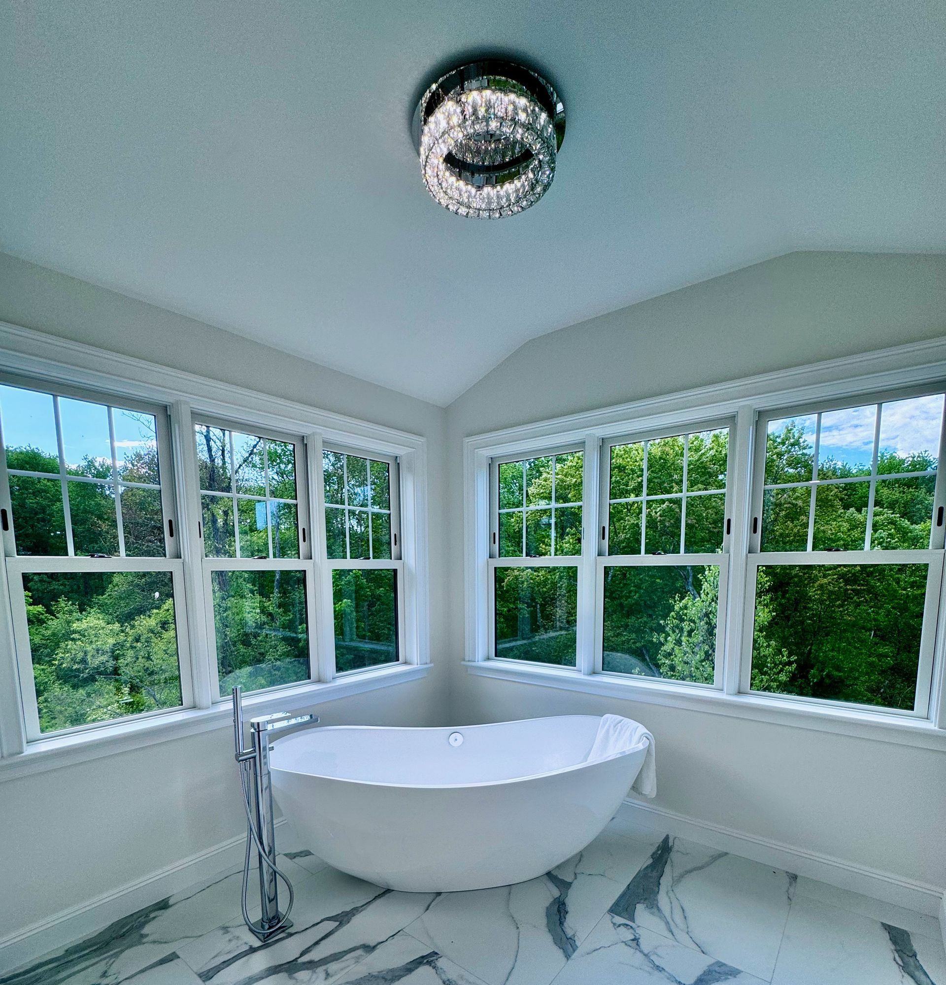 A bathroom with a bathtub and lots of windows