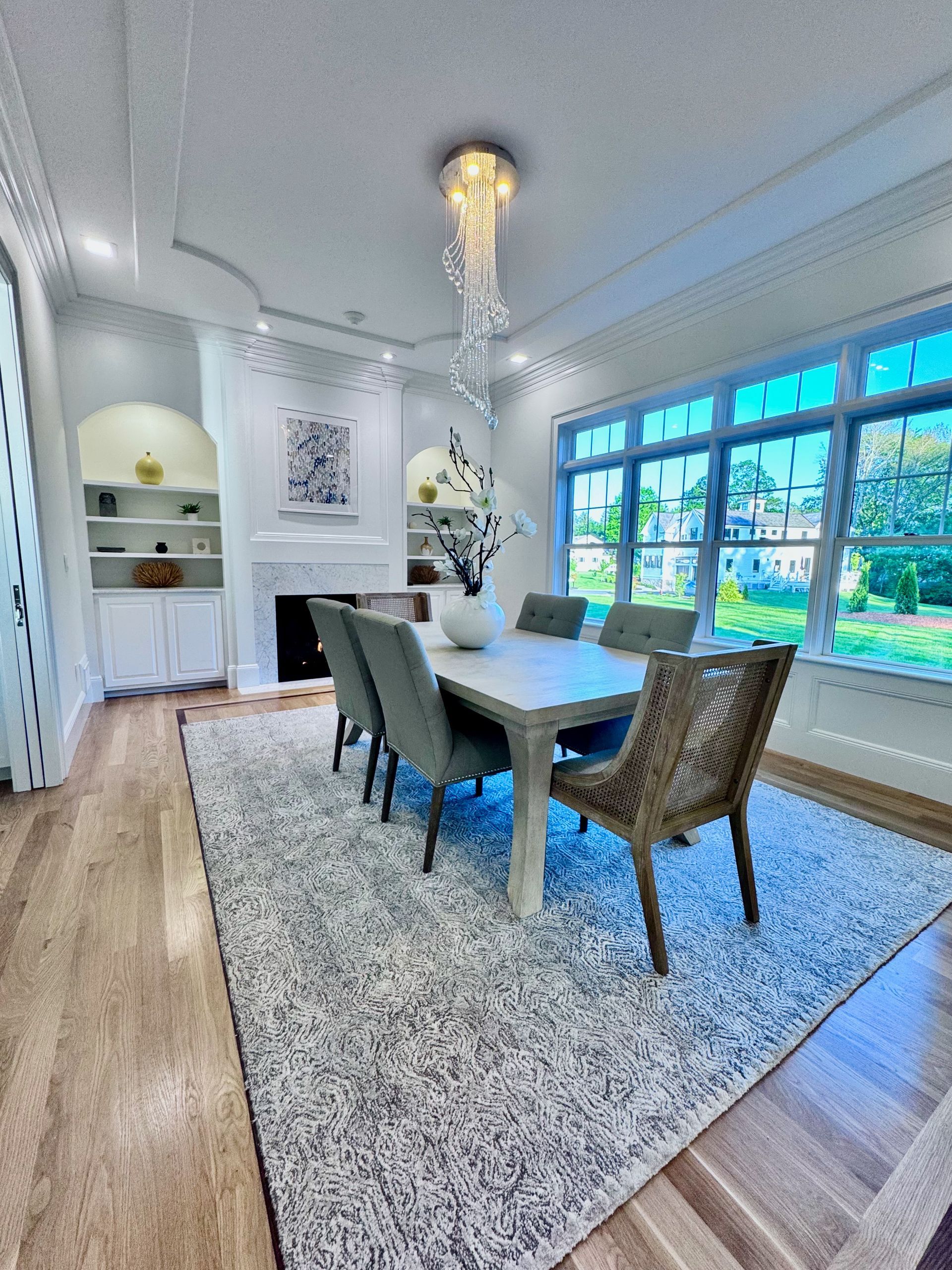 A dining room with a table and chairs and a rug.