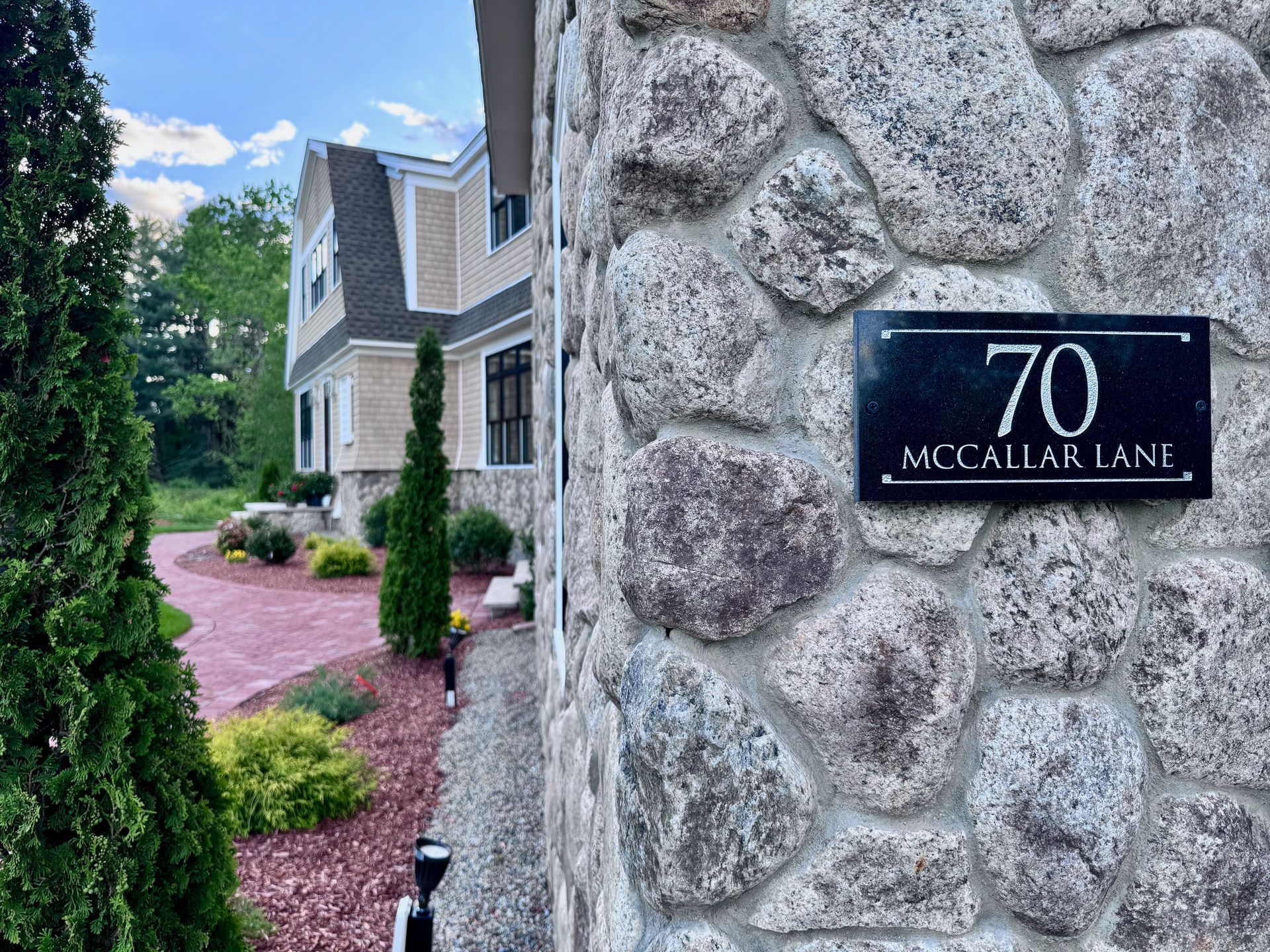 A stone wall with a sign on it that says 70 mccallum lane
