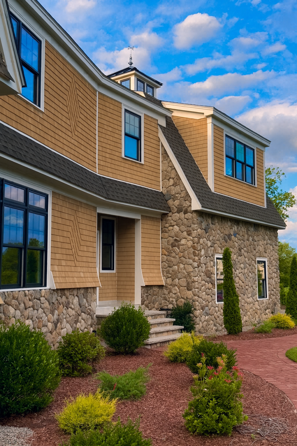A large house is sitting on top of a lush green field.