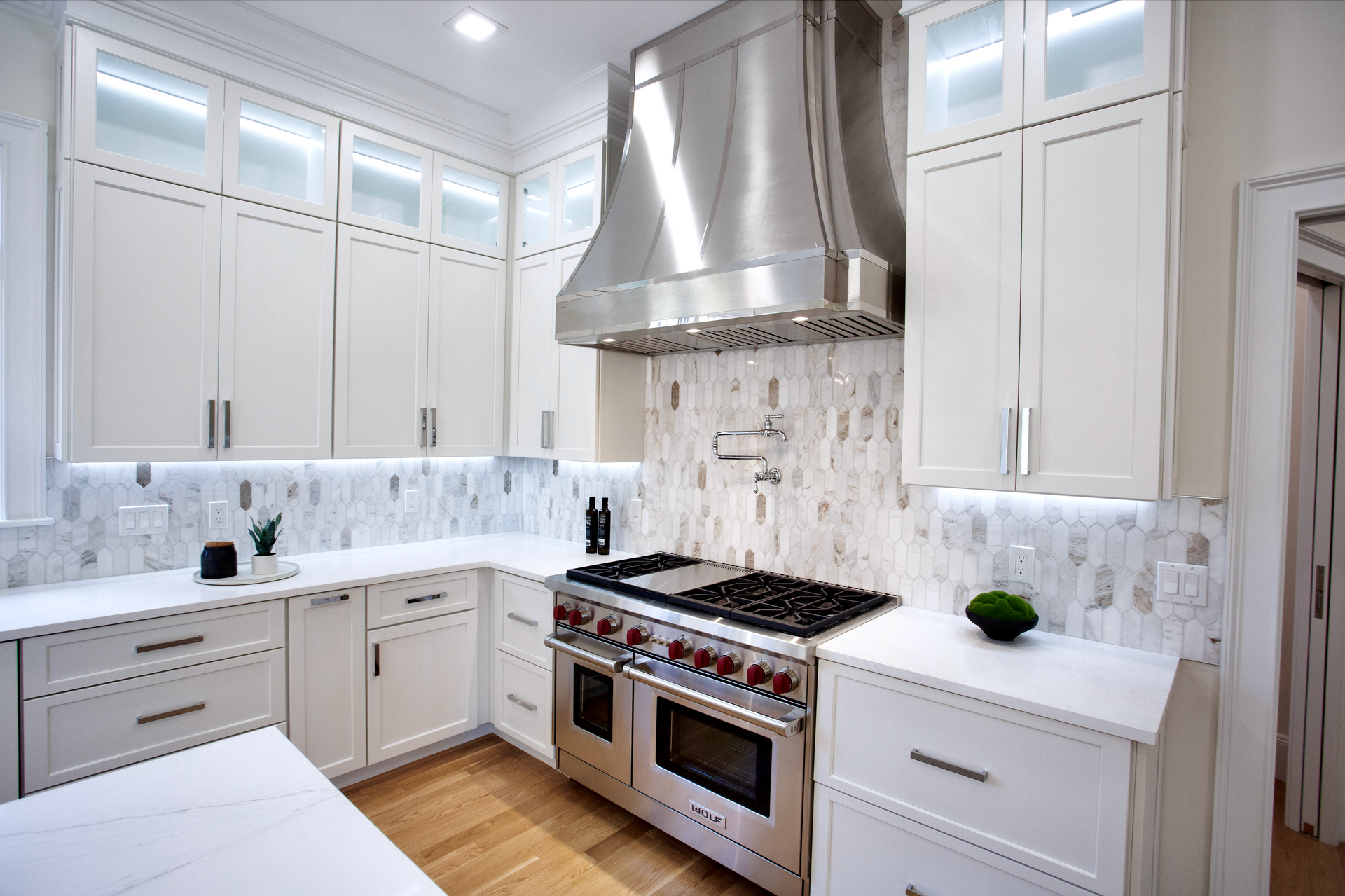 A kitchen with white cabinets and stainless steel appliances
