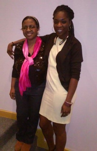 Two women posing for a picture with one wearing a pink scarf