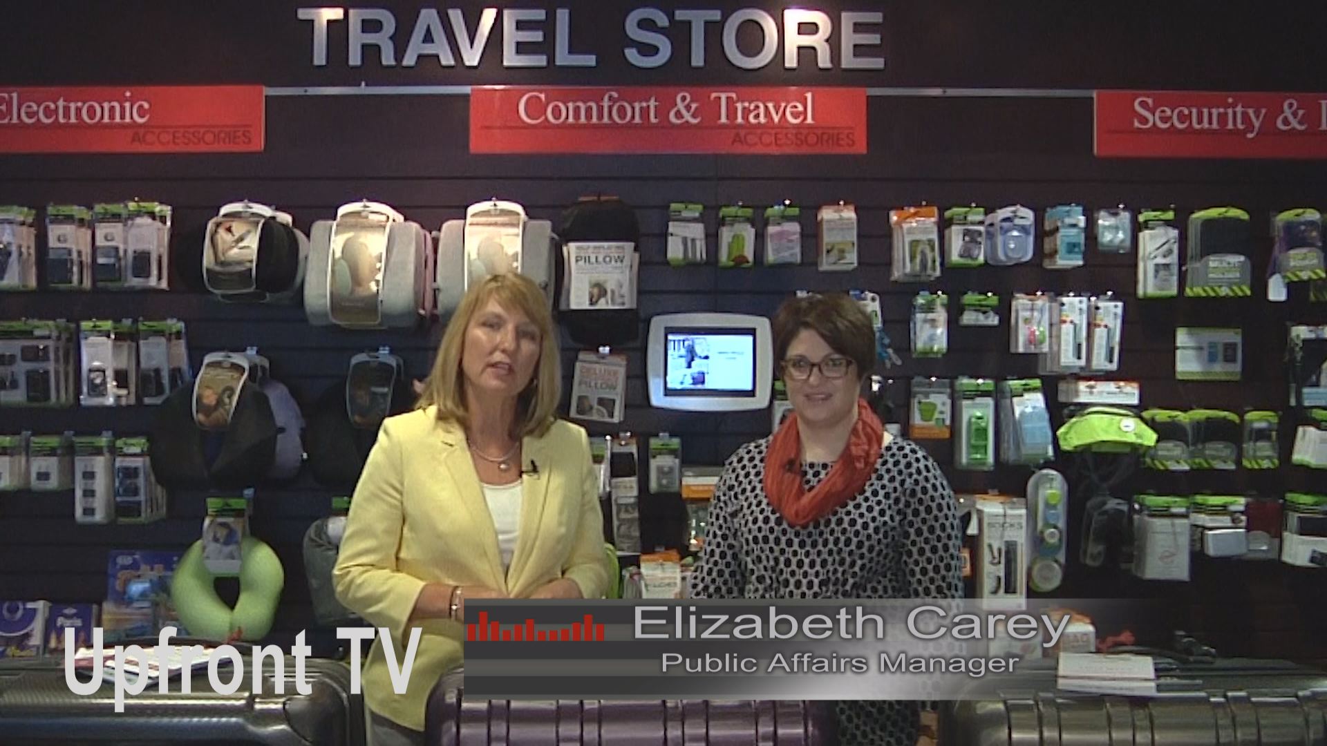 Two women are standing in front of a travel store