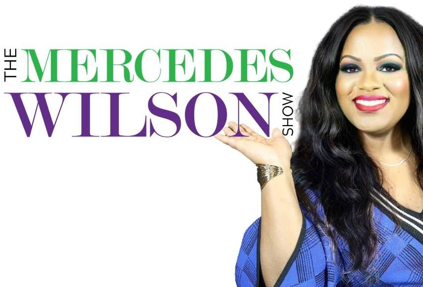 A woman is smiling in front of the mercedes wilson show logo