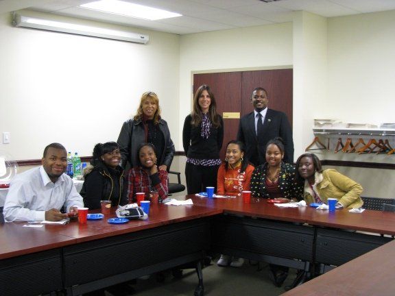 A group of people are posing for a picture while sitting around a table