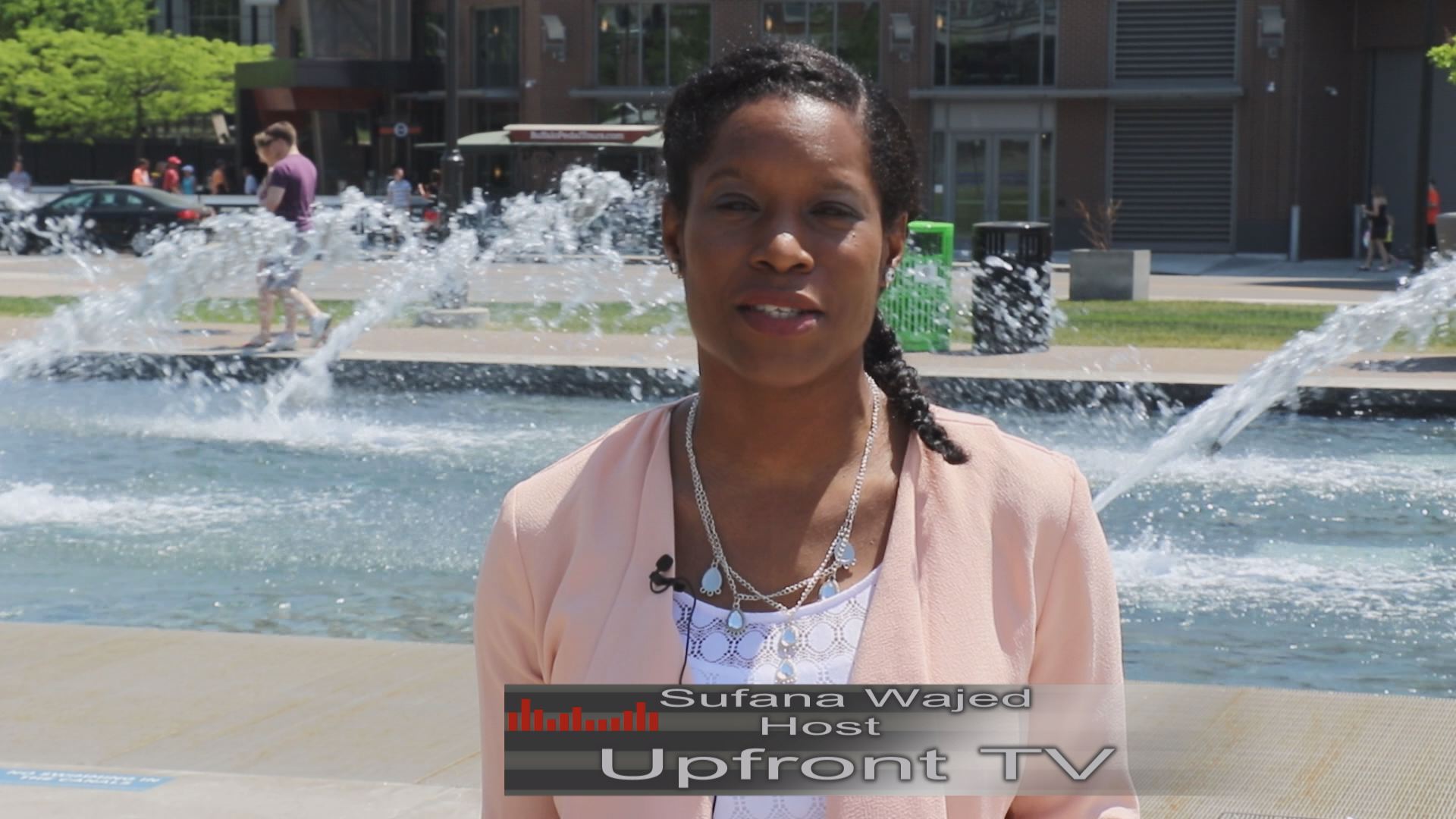 A woman standing in front of a fountain with upfront tv written on the bottom