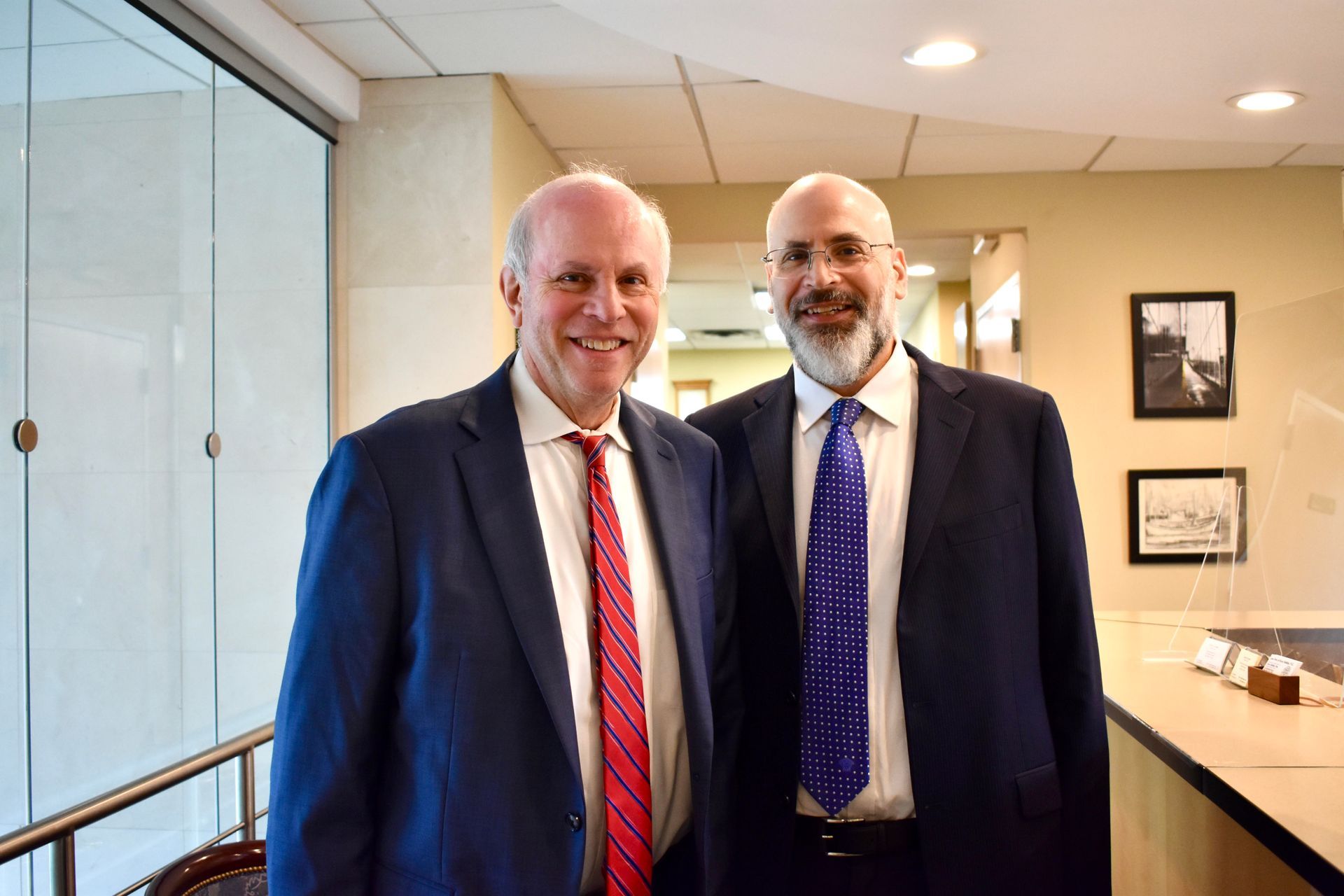 A man with a backpack is standing next to a lake in the woods.