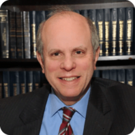 A man in a white shirt and tie is smiling