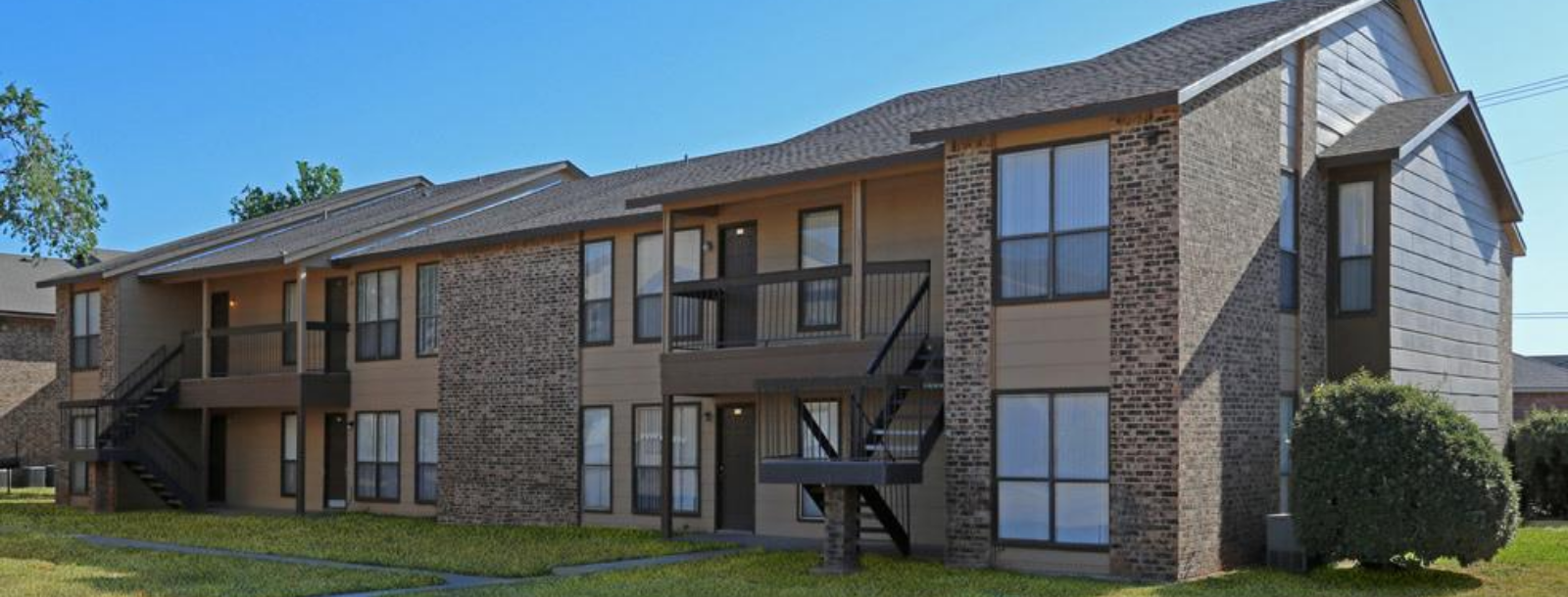 Two-story brick-and-siding apartment building with exterior stairs and balconies.