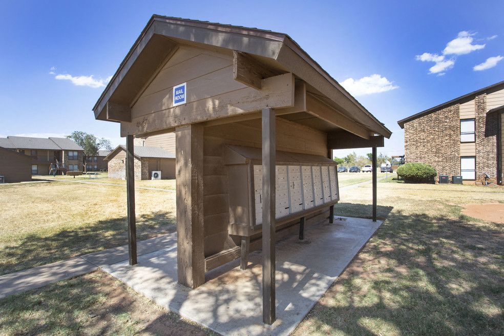 Wooden shelter with a row of mailboxes at a residential apartment complex.