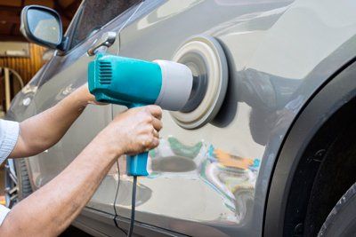 Auto Paintless Dent — Hands Polish A Car Body With Polisher in Edison, NJ