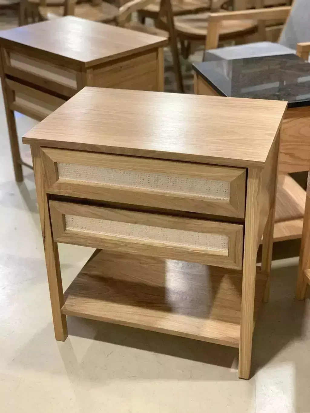 Mesita de noche de madera con dos cajones y estante inferior.