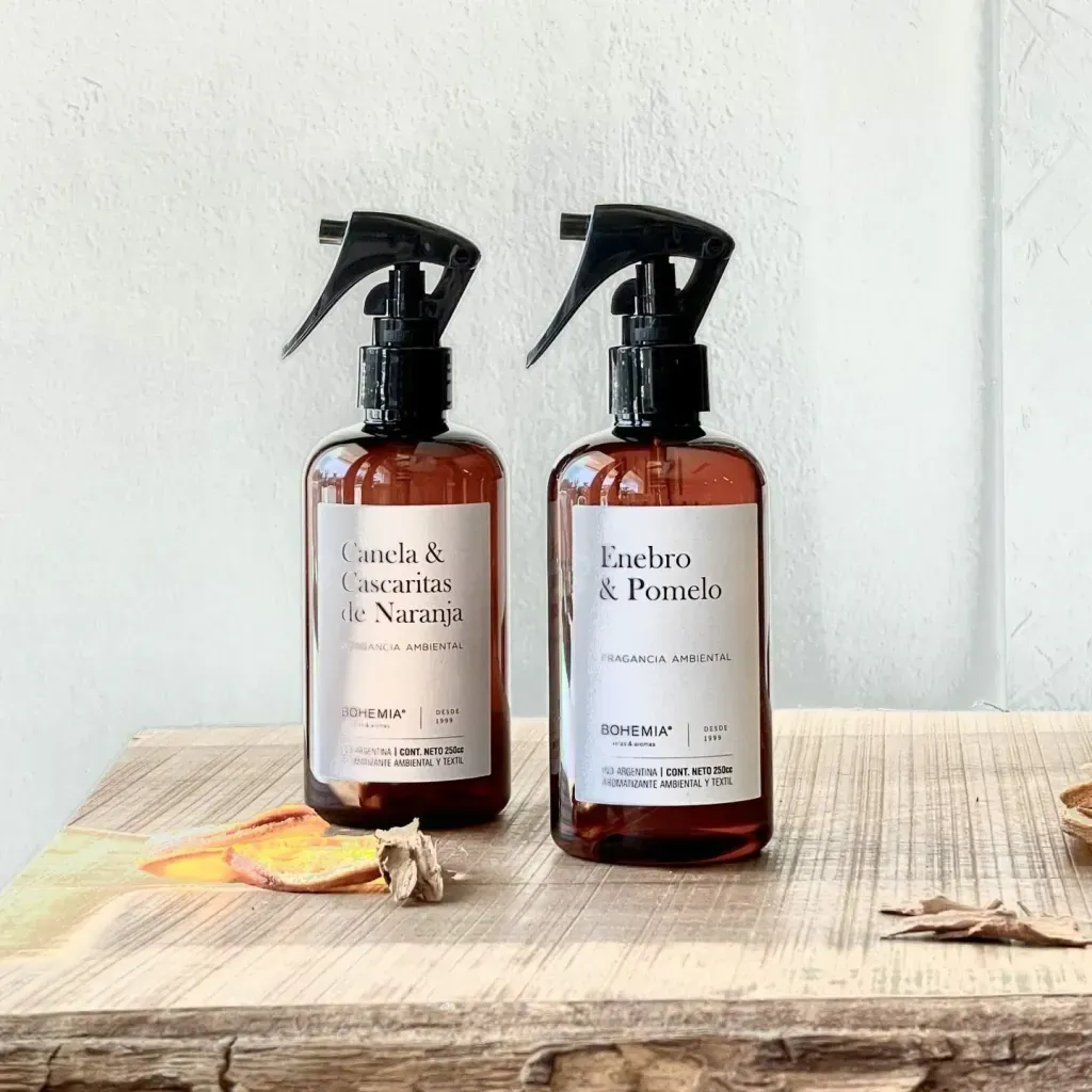 Dos botellas de spray de color ámbar sobre una mesa de madera